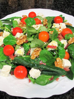 Una foto de Ensalada de espinaca, canónigos, feta, cherry y jamón curado