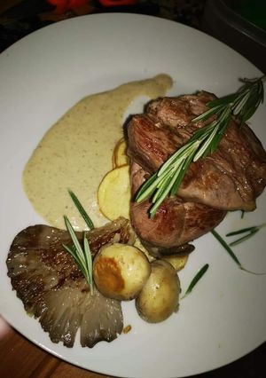 Una foto de Tubule de cordero con salsa portobello, setas y patatas