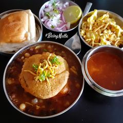 A picture of Misal Pav with spicy Tari.