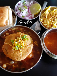 A picture of Misal Pav with spicy Tari.