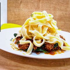 A picture of Tagliatelle bolognese with spinach.
