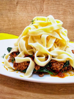 A picture of Tagliatelle bolognese with spinach.