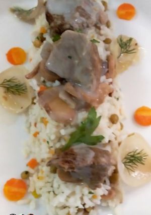 Une photo de Blanquette de veau avec un riz printanier et oignon glacé àblanc