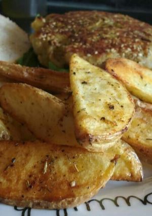 Una foto de Hamburguesa de atún al curry con patatas gajo al horno