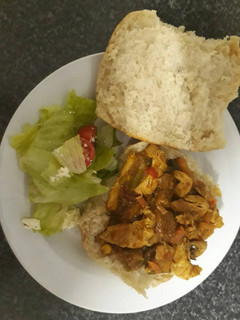 A picture of Chicken stir fry, panini bread with green salad.