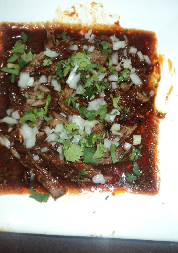 Una foto de Birria de res adobada  con chile frito y jugo de naranja agria las Correa en cazuela de barro
