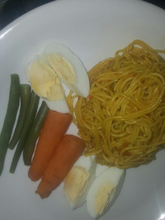 A picture of Spaghetti with boiled eggs and veggies.