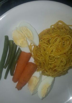 A picture of Spaghetti with boiled eggs and veggies.