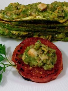 Una foto de Timbal de calabacines y tomates asados con crema de berberechos y gambas al ajillo