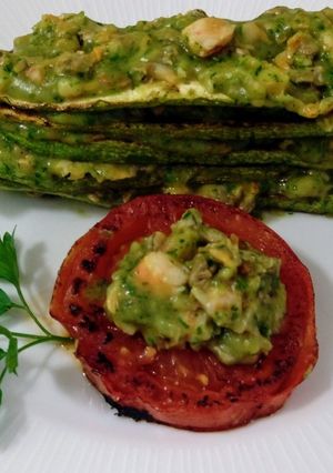 Una foto de Timbal de calabacines y tomates asados con crema de berberechos y gambas al ajillo