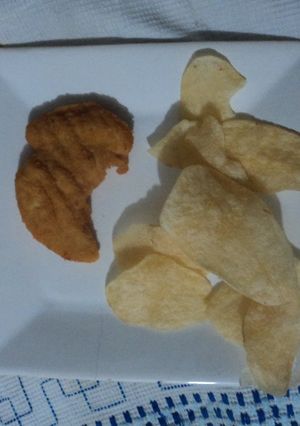 Una foto de Pechuguitas empanizadas con doritos y papas doradas caseras o de bolsa