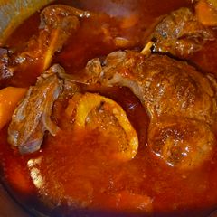 A picture of Beef Stew with Carrots and tomatoes.