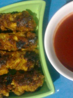 A picture of Barbequed Chicken wings with Chilli Sauce.