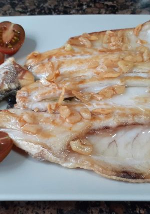 Una foto de Lubina a la plancha con ajos confitados