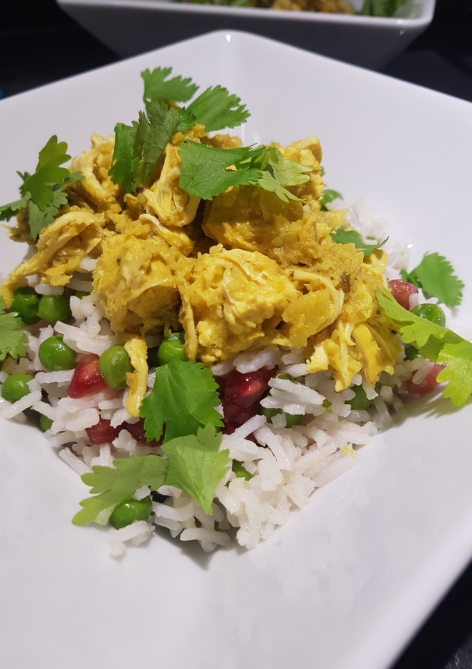 Una foto de Curry de pollo y coco tostado sobre arroz basmati con guisantes y granada