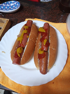 Una foto de Perrito caliente cebolla crujiente y queso rallado