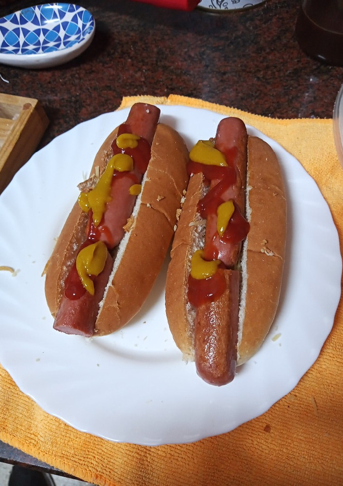 Una foto de Perrito caliente cebolla crujiente y queso rallado