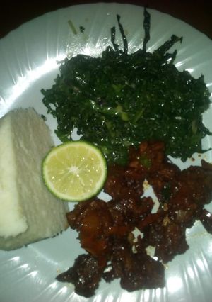 A picture of Fried beef and steamed sukuma wiki.