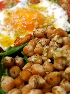 Una foto de Ensalada de espinacas, garbanzos tostados, tomate, huevo y aguacate