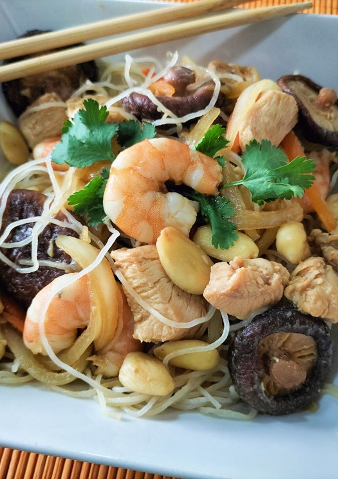 Una foto de Wok de fideos de arroz con pollo, langostinos, verduras y salsas chinas