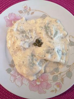 Una foto de Ravioles de espinaca y ricotta en salsa de queso parmesano