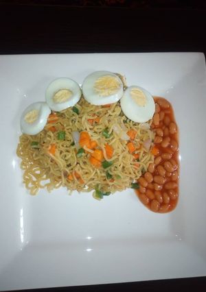 A picture of Veggies noodles with baked beans and egg.