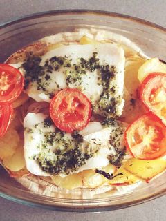 Una foto de Merluza al horno con guarnición de patatas y tomate asado