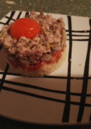 Foto principal de Tartar ibérico con tomates y yema curada sobre cama de couscous