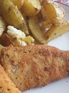 Una foto de Abadejo crujiente con patatas gajo especiadas y queso de cabra