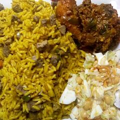 A picture of Fried rice with pepper chicken and Coleslaw.