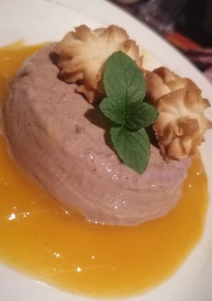 Una foto de Panna cotta de chocolate, coulis de mango y pastisetas