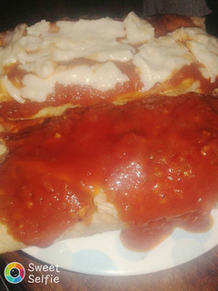Una foto de Canelones con salsa blanca y salsa de tomates