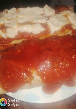 Una foto de Canelones con salsa blanca y salsa de tomates