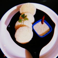 A picture of Idli with coconut chutney.