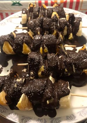 Una foto de Pinchito de plátano y mandarina con chocolate negro 99%
