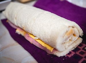 Una foto de Niño envuelto de jamón y queso amarillo