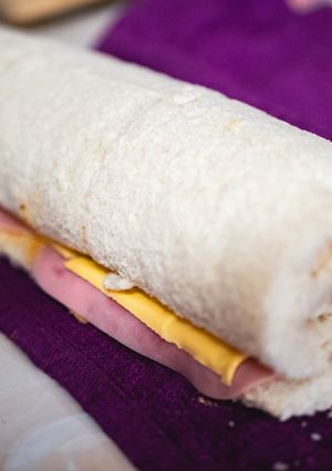 Una foto de Niño envuelto de jamón y queso amarillo