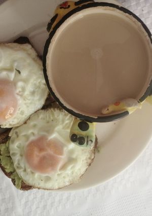 Una foto de Tostadas con huevo y aguacate con café