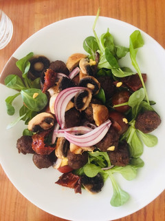 Una foto de Ensalada templada con mini albóndigas y champiñones con aliño de mostaza y miel