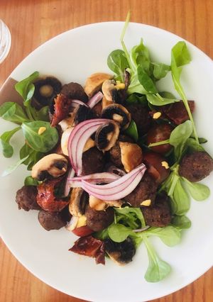 Una foto de Ensalada templada con mini albóndigas y champiñones con aliño de mostaza y miel