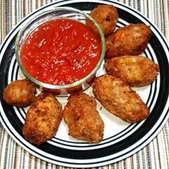 A picture of Potato nuggets served with marinara sauce.