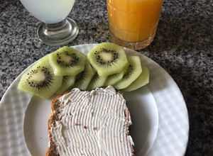 Una foto de Así arrancamos las mañanas, vaso de agua con limón, un jugo de naranja exprimido, tostada y fruta