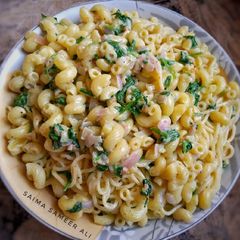 A picture of Macaroni speghittie white sauce spinach bowl.