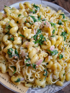 A picture of Macaroni speghittie white sauce spinach bowl.