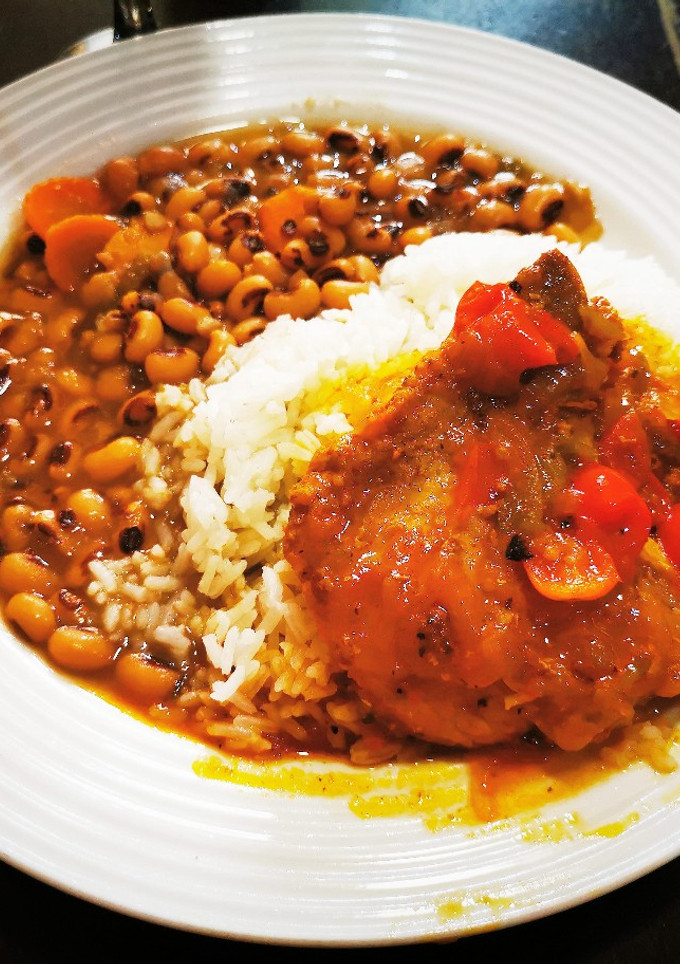 Una foto de Chuleta de Cerdo a la Rubenccini, Arroz & Frijoles de Ojitos Negros