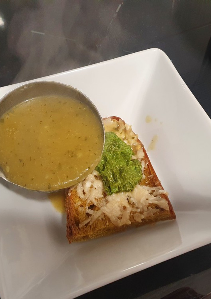 Una foto de Crema de calabacín y cebolleta con pesto y tosta gratinada
