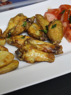 Una foto de Alitas de pollo con patatas y tomate
