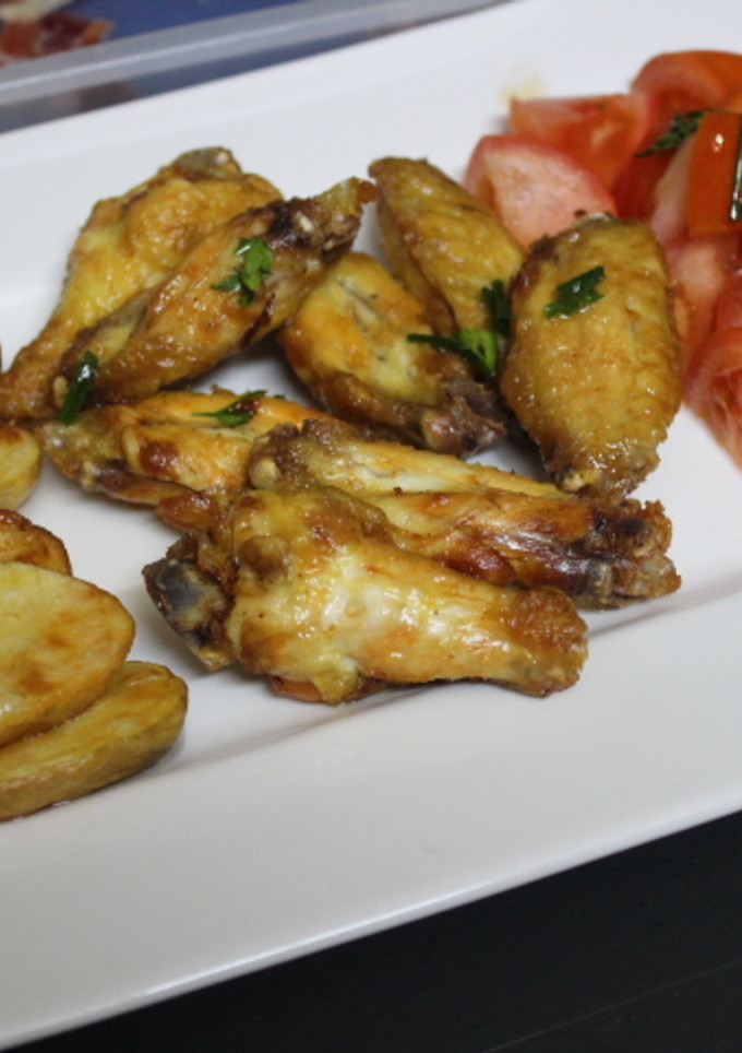 Una foto de Alitas de pollo con patatas y tomate