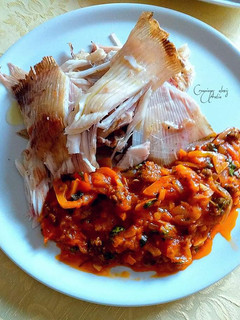 Una foto de Pez raya a las brasas acompañado con salsa de tomates