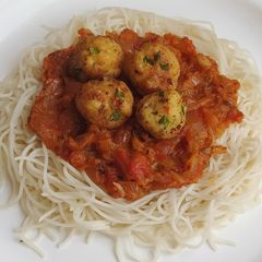 A picture of Spaghetti in bolongnese sauce with golden paneer balls.